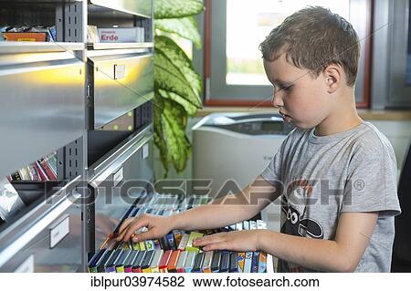 "Boy, 7 years, looking for children's films at the DVD shelf, media library of the city library, Coswig, Saxony, Germany, Europe" View Large Photo Image Stock Image - "Boy, 7 years, looking for children's films at the DVD shelf, media library of the city library, Coswig, Saxony, Germany, Europe". Fotosearch