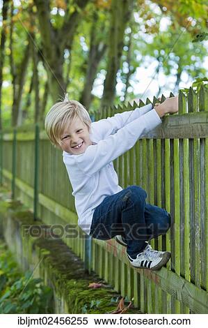 "Boy, 7 years old, hanging on a wooden fence" View Large Photo Image Stock Photography - "Boy, 7 years old, hanging on a wooden fence". Fotosearch