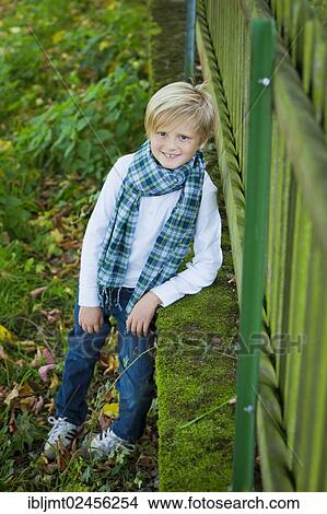 "Boy, 7 years old, leaning against a wooden fence" View Large Photo Image Picture - "Boy, 7 years old, leaning against a wooden fence". Fotosearch