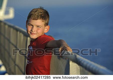 Stock Photography - Boy, 8, leaning against a ship's railing. Fotosearch