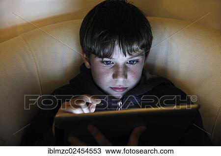 Stock Image - "Boy, 8, using an iPad, Ringsheim, Baden-Wuerttemberg, Germany, Europe". Fotosearch