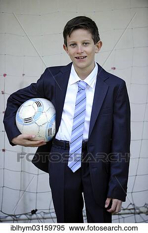 "Boy, 9 years, in a suit holding a football" View Large Photo Image Stock Photography - "Boy, 9 years, in a suit holding a football". Fotosearch