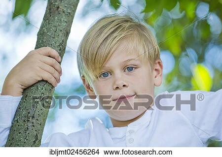 "Boy, 9 years old, climbing on a tree" View Large Photo Image Picture - "Boy, 9 years old, climbing on a tree". Fotosearch