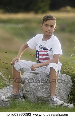 "Boy, 9 years old, sitting on rock" View Large Photo Image Stock Image - "Boy, 9 years old, sitting on rock". Fotosearch