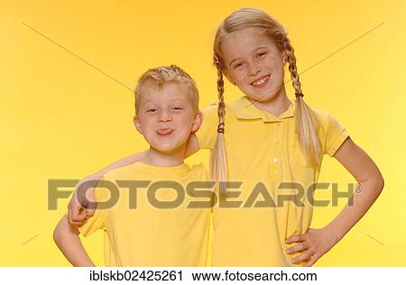 Stock Image - "Boy and girl, brother and sister, standing arm in arm, smiling". Fotosearch