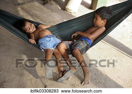"Boy and girl lying in a hammock, Trapang Village, Bathi District, Takeo Province, Cambodia, Asia" View Large Photo Image Stock Image - "Boy and girl lying in a hammock, Trapang Village, Bathi District, Takeo Province, Cambodia, Asia". Fotosearch