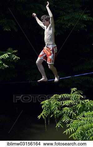 "Boy balancing on a slackline, trend sport, over the Neckar river, Heilbronn, Baden-Wurttemberg, Germany, Europe" View Large Photo Image Picture - "Boy balancing on a slackline, trend sport, over the Neckar river, Heilbronn, Baden-Wurttemberg, Germany, Europe". Fotosearch