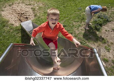 Stock Photo - "Boy climbing up a slide on a playground, Burgwallinsel island, Lake Teterower See, Mecklenburgische Schweiz region, Mecklenburg-Western Pomerania, Germany, Europe". Fotosearch