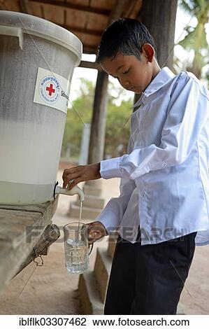 "Boy drinking filtered water, the water filter has been distributed as part of a hygiene campaign from a charity, Lompong Commune, Bathi District, Takeo Province, Cambodia, Asia" View Large Photo Image Stock Image - "Boy drinking filtered water, the water filter has been distributed as part of a hygiene campaign from a charity, Lompong Commune, Bathi District, Takeo Province, Cambodia, Asia". Fotosearch