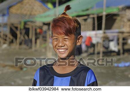 Picture - "Boy from the slums with dyed hair and fashionable hairstyle, Irrawaddy, Mandalay, Mandalay District, Myanmar, Asia". Fotosearch