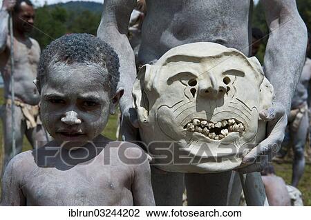 Stock Image - "Boy from the tribe of the Mudmen during the traditional Sing Sing in the highlands, Enga, Highlands, Papua New Guinea, Oceania". Fotosearch