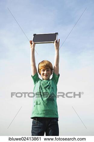 Boy holding a solar panel towards the sun View Large Photo Image Stock Image - Boy holding a solar panel towards the sun. Fotosearch