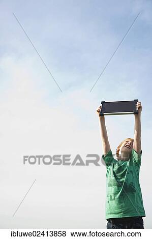 Boy holding a solar panel towards the sun View Large Photo Image Stock Photo - Boy holding a solar panel towards the sun. Fotosearch