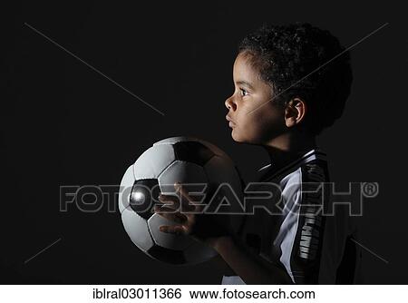 "Boy in a jersey holding a football, Germany, Europe" View Large Photo Image Stock Photograph - "Boy in a jersey holding a football, Germany, Europe". Fotosearch