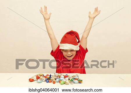 Stock Image - Boy in front of Christmas candies. Fotosearch