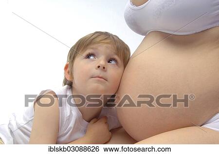 Boy listening to the belly of his pregnant mother View Large Photo Image Stock Photograph - Boy listening to the belly of his pregnant mother. Fotosearch