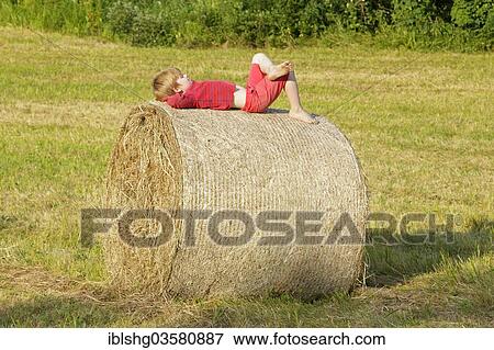 "Boy lying on a bale of straw, Germany, Europe" View Large Photo Image Stock Photo - "Boy lying on a bale of straw, Germany, Europe". Fotosearch