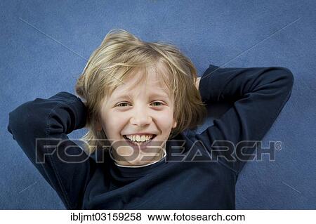 "Boy lying on the floor, portrait, Germany, Europe" View Large Photo Image Stock Photo - "Boy lying on the floor, portrait, Germany, Europe". Fotosearch