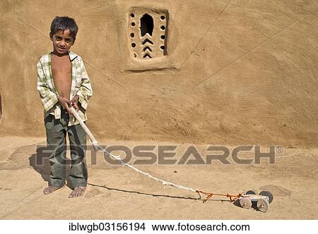 "Boy playing with a home-made toy car outside a mud house, Wuste Thar, Rajasthan, India, Asia" View Large Photo Image Picture - "Boy playing with a home-made toy car outside a mud house, Wuste Thar, Rajasthan, India, Asia". Fotosearch