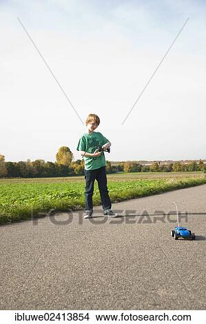 Boy playing with his radio-controlled model car View Large Photo Image Picture - Boy playing with his radio-controlled model car. Fotosearch