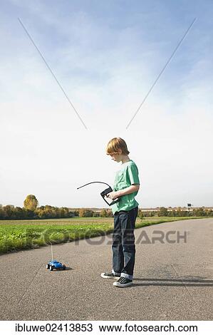 Boy playing with his radio-controlled model car View Large Photo Image Stock Image - Boy playing with his radio-controlled model car. Fotosearch
