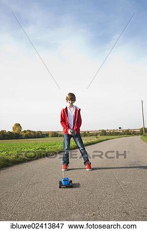 Boy playing with his radio-controlled model car View Large Photo Image Stock Photo - Boy playing with his radio-controlled model car. Fotosearch
