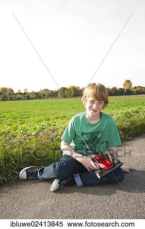Boy playing with his radio-controlled model car View Large Photo Image Stock Photography - Boy playing with his radio-controlled model car. Fotosearch