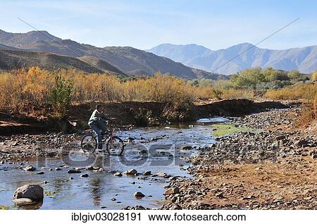 "Boy rides his bike through a small river in a barren landscape, Souss-Massa-Draa, Hoher Atlas, Morocco, Africa" View Large Photo Image Stock Image - "Boy rides his bike through a small river in a barren landscape, Souss-Massa-Draa, Hoher Atlas, Morocco, Africa". Fotosearch