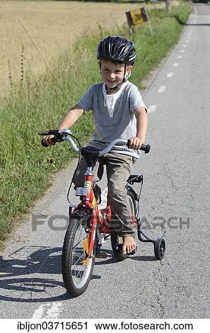 "Boy riding a bicycle with training wheels, Stora Herrestad, Ystad, Scania, Sweden, Europe" View Large Photo Image Stock Image - "Boy riding a bicycle with training wheels, Stora Herrestad, Ystad, Scania, Sweden, Europe". Fotosearch