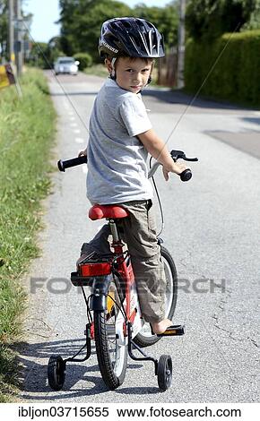 "Boy riding a bicycle with training wheels, Stora Herrestad, Ystad, Scania, Sweden, Europe" View Large Photo Image Stock Photography - "Boy riding a bicycle with training wheels, Stora Herrestad, Ystad, Scania, Sweden, Europe". Fotosearch