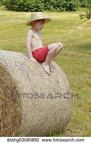 "Boy sitting on a bale of straw, Germany, Europe" View Large Photo Image Stock Image - "Boy sitting on a bale of straw, Germany, Europe". Fotosearch