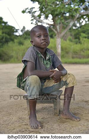 "Boy sitting on a stool, Nkala, Bandundu Province, Democratic Republic of the Congo" View Large Photo Image Picture - "Boy sitting on a stool, Nkala, Bandundu Province, Democratic Republic of the Congo". Fotosearch