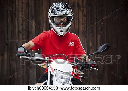 "Boy wearing a helmet sitting on a motorcycle, Reith im Alpbachtal, Kufstein District, North Tirol, Tirol, Austria, Europe" View Large Photo Image Stock Image - "Boy wearing a helmet sitting on a motorcycle, Reith im Alpbachtal, Kufstein District, North Tirol, Tirol, Austria, Europe". Fotosearch