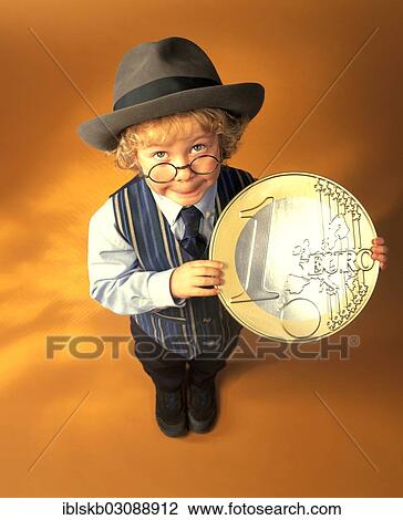 Boy wearing business clothes holding a large euro coin View Large Photo Image Stock Image - Boy wearing business clothes holding a large euro coin. Fotosearch