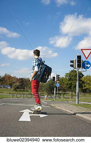 Boy with a school bag and a skateboard on a street View Large Photo Image Stock Image - Boy with a school bag and a skateboard on a street. Fotosearch