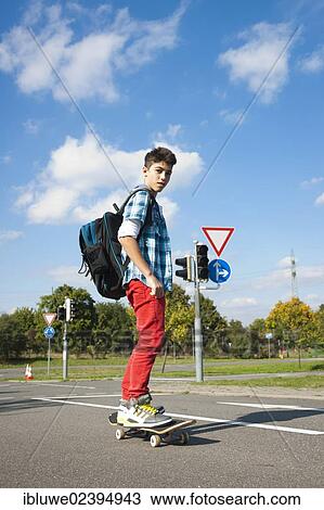 Boy with a school bag and a skateboard on a street View Large Photo Image Stock Image - Boy with a school bag and a skateboard on a street. Fotosearch