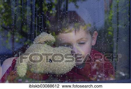 "Boy with closed eyes at a window with water drops, holding a stuffed animal in his arms" View Large Photo Image Stock Image - "Boy with closed eyes at a window with water drops, holding a stuffed animal in his arms". Fotosearch