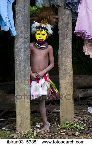 Stock Image - "Boy with colourful decorations and face paint is celebrating at the traditional Sing Sing gathering in the highlands, Paya, Papua New Guinea, Oceania". Fotosearch