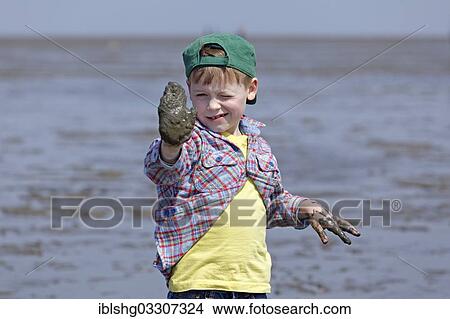 "Boy with his hands full of mud in the mudflats of the Wadden Sea, Duhnen, Cuxhaven, Lower Saxony, Germany, Europe" View Large Photo Image Picture - "Boy with his hands full of mud in the mudflats of the Wadden Sea, Duhnen, Cuxhaven, Lower Saxony, Germany, Europe". Fotosearch