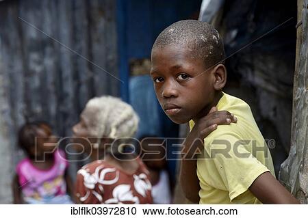 Stock Image - "Boy with serious look, Camp Icare for earthquake refugees, Fort National, Port-au-Prince, Haiti, North America". Fotosearch