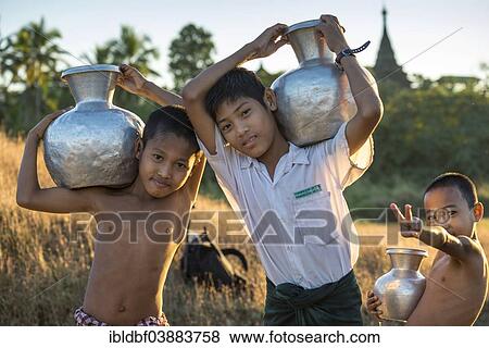 "Boys carrying water in water containers made of aluminium, Mrauk U, Sittwe District, Rakhine State, Myanmar, Asia" View Large Photo Image Stock Photo - "Boys carrying water in water containers made of aluminium, Mrauk U, Sittwe District, Rakhine State, Myanmar, Asia". Fotosearch