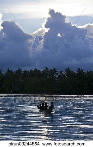 "Boys in a canoe in the Marovo Lagoon, in backlight, Marovo Lagoon, Western Province, Solomon Islands, Oceania" View Large Photo Image Picture - "Boys in a canoe in the Marovo Lagoon, in backlight, Marovo Lagoon, Western Province, Solomon Islands, Oceania". Fotosearch