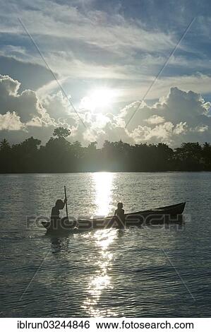 "Boys in a canoe in the Marovo Lagoon, in backlight, Marovo Lagoon, Western Province, Solomon Islands, Oceania" View Large Photo Image Stock Photograph - "Boys in a canoe in the Marovo Lagoon, in backlight, Marovo Lagoon, Western Province, Solomon Islands, Oceania". Fotosearch