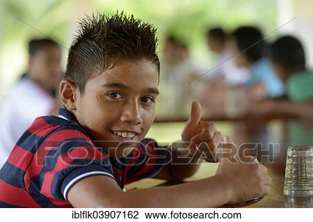 Stock Image - "Brazilian boy signaling OK with his thumbs up, social project for street children, Maranguape, Ceara, Brazil, South America". Fotosearch