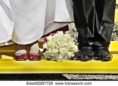 Bridal bouquet lying between the feet of the bride and the groom View Large Photo Image Stock Photo - Bridal bouquet lying between the feet of the bride and the groom. Fotosearch
