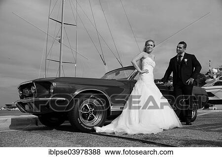 Bride and groom posing in front of a Ford Mustang at a harbour View Large Photo Image Stock Photo - Bride and groom posing in front of a Ford Mustang at a harbour. Fotosearch