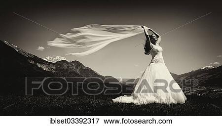 Stock Photo - "Bride holding a flowing scarf in the Tyrolean Alps, Inntal, Innsbruck, Tyrol, Austria, Europe". Fotosearch