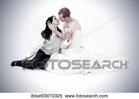Stock Photography - "Bride wearing a suit kissing a groom wearing a wedding dress, exchange of wedding clothing, Austria, Europe". Fotosearch