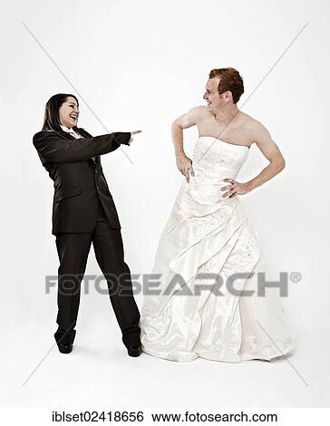 Stock Photograph - Bride wearing a suit laughing at a groom wearing a wedding dress. Fotosearch