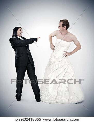 Stock Photography - Bride wearing a suit laughing at a groom wearing a wedding dress. Fotosearch